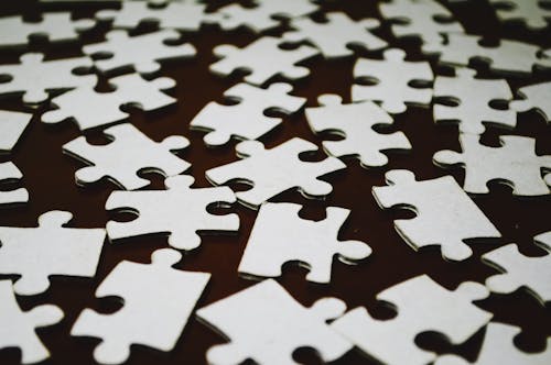 White Puzzle Pieces on a Brown Surface