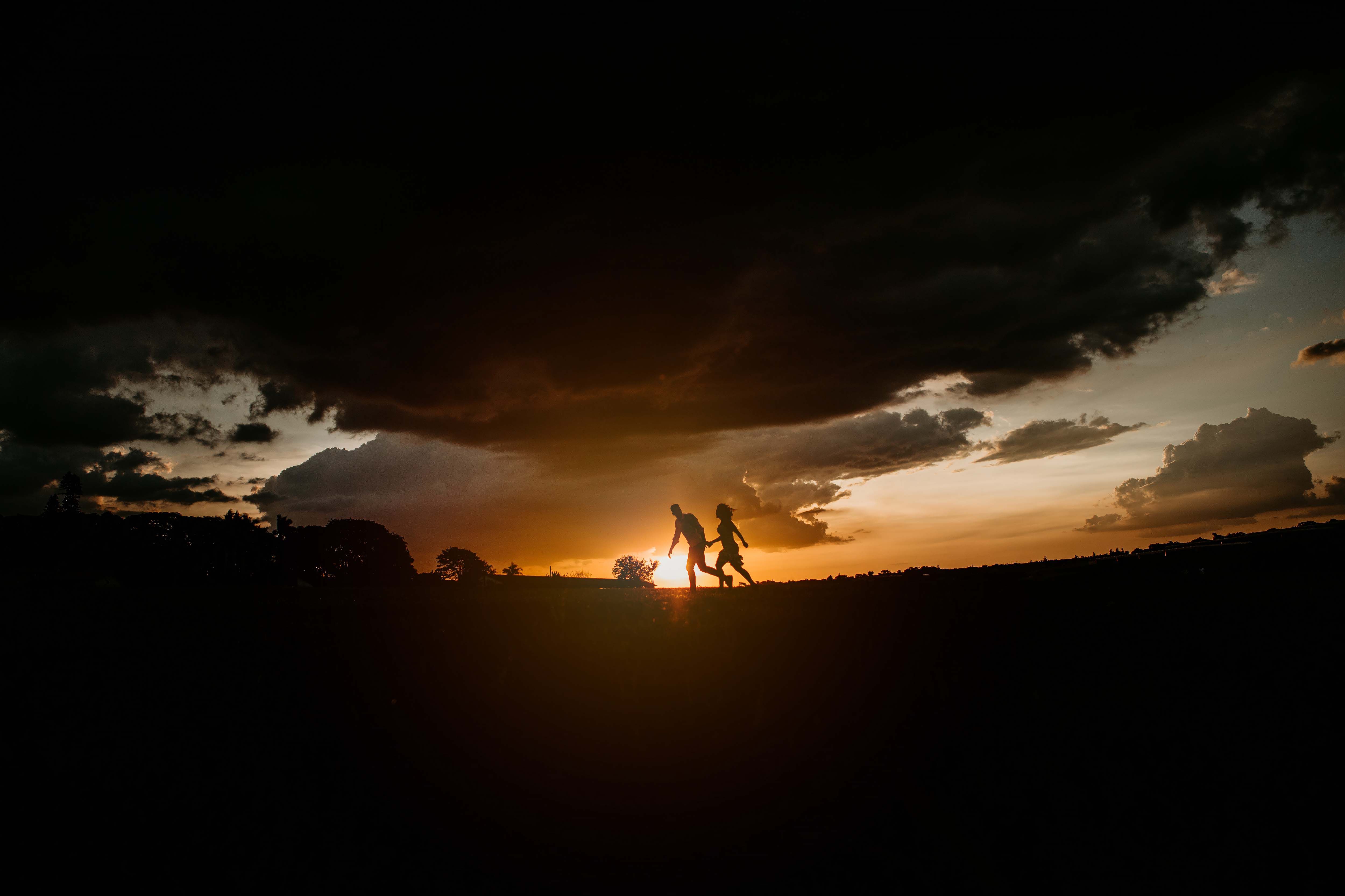 Silhouette of a couple holding hands against a stunning sunset in Holambra, Brazil.