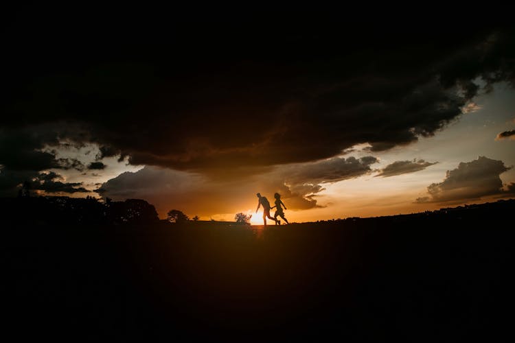 Silhouette Of Sweet Couple Walking On The Ground During Golden Hour