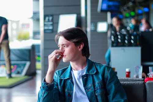 Thoughtful young male chilling in modern cafe in daytime