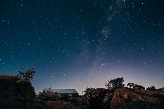 星光夜空迷人地笼罩在乡村房屋和崎岖的景观之上