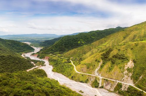 Free Picturesque scenery of mountains covered with green trees and grass and river flowing in middle Stock Photo