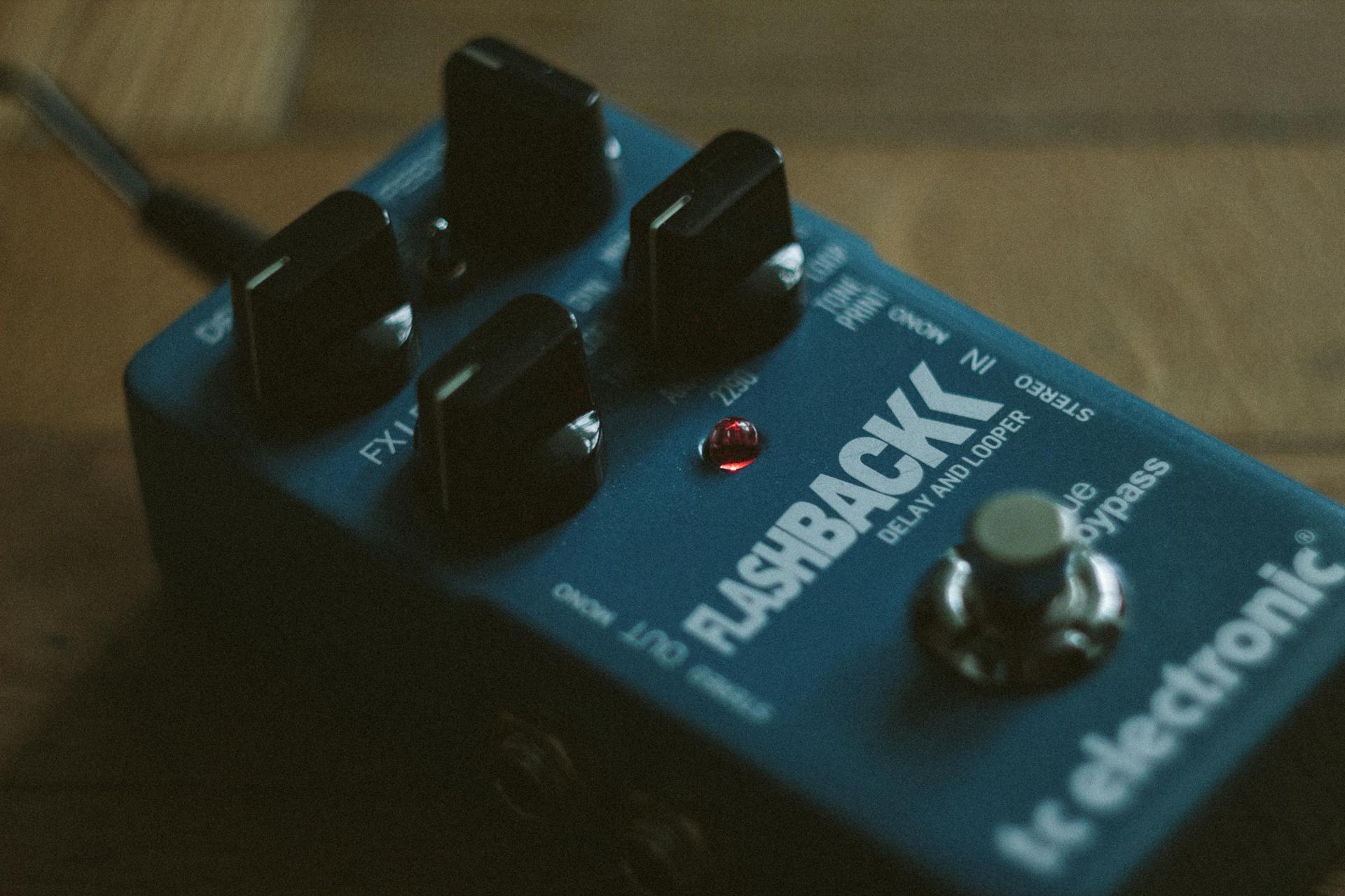 A detailed view of a blue Flashback delay and looper pedal with control knobs.