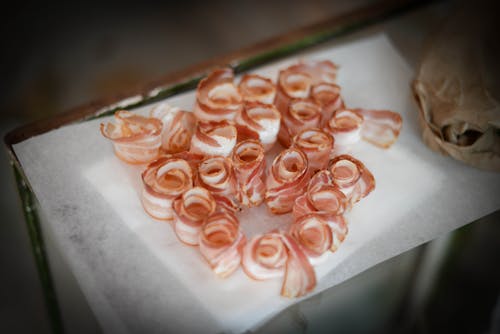 Delicious bacon slices on napkin on table