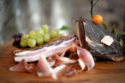 Delicious jamon with grapes served on table