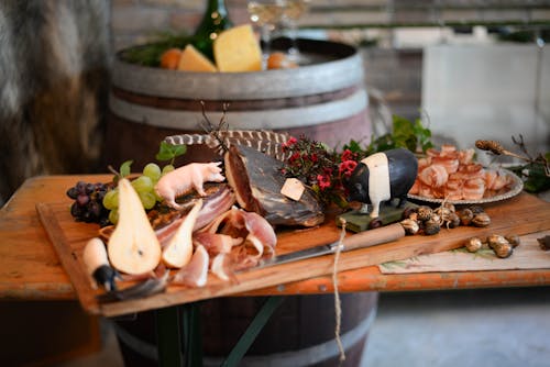 Delicious meat appetizers with fruits on wooden desk