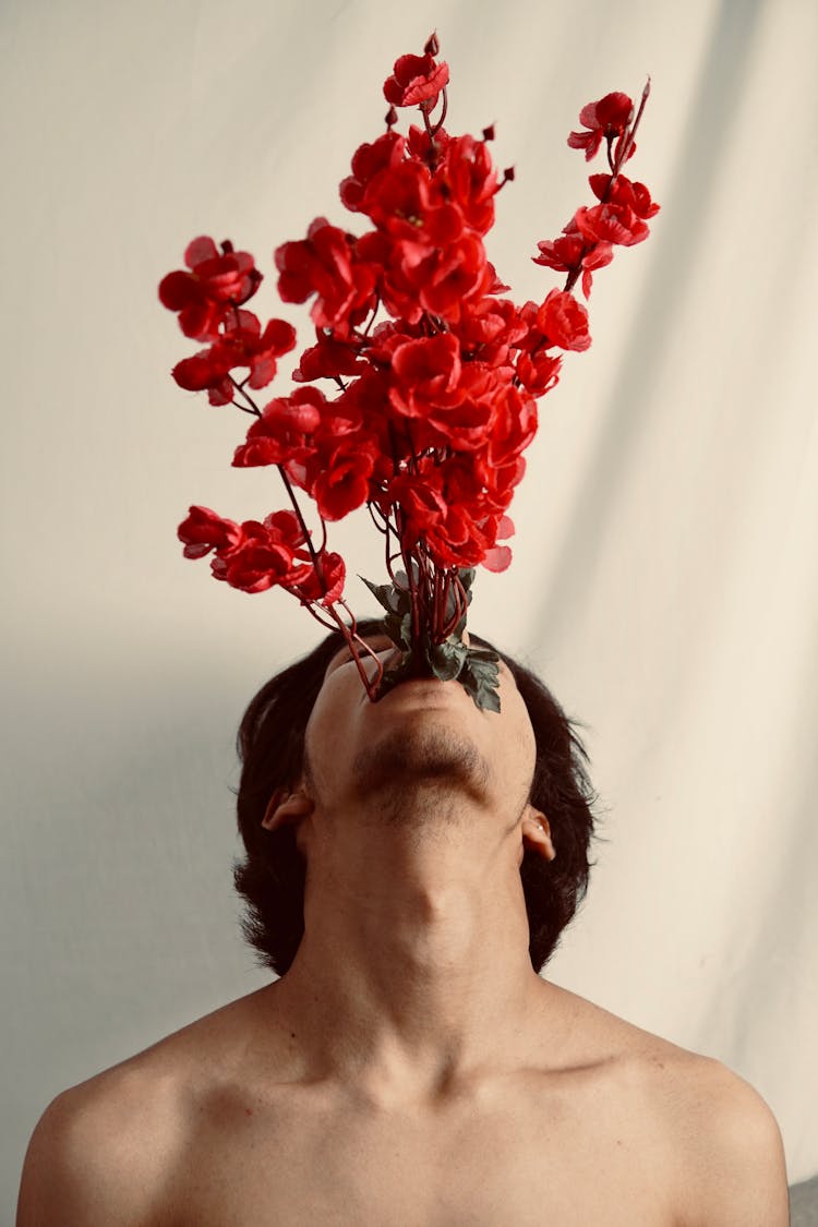 Young Man With Red Flowers In Mouth