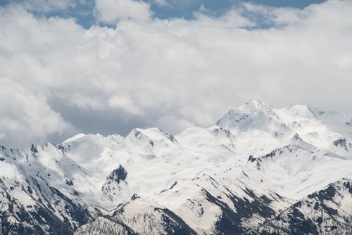 Snow Covered Mountains Under Cloudy Sky