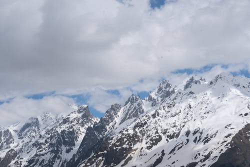 Snow Covered Mountains Under Cloudy Sky