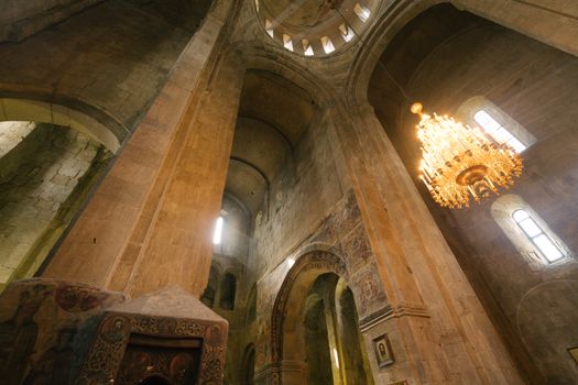 Stunning interior view of a historical cathedral, capturing the grandeur and architectural elegance with a glowing chandelier.