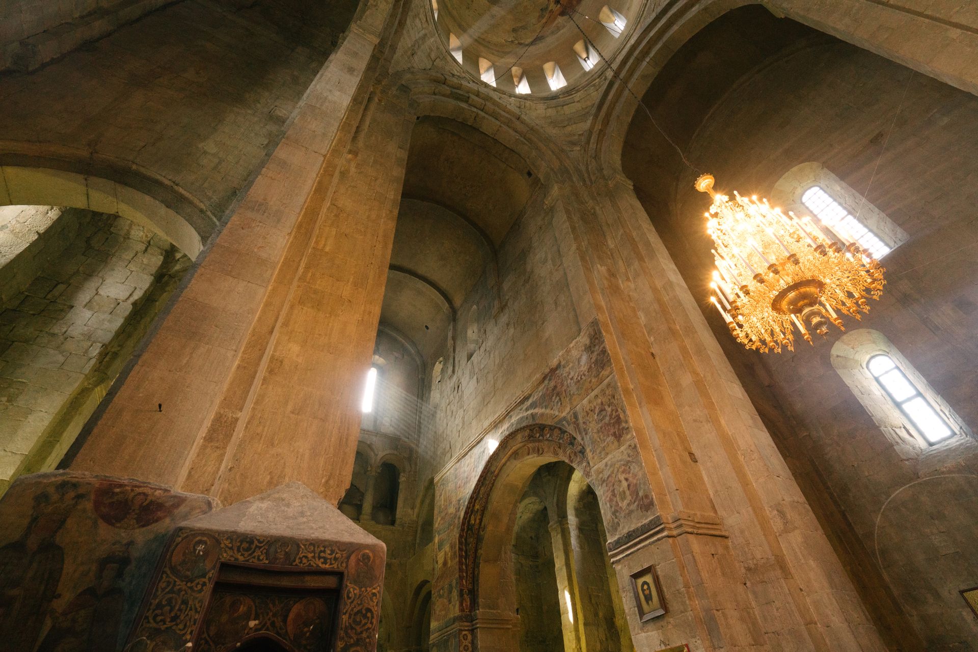 Stunning interior view of a historical cathedral, capturing the grandeur and architectural elegance with a glowing chandelier.
