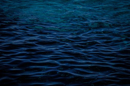 A mesmerizing view of dark blue ocean waves creating a soothing ripple effect on the water surface.