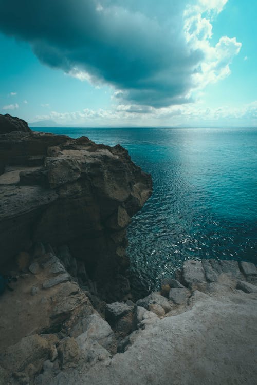 Photo of Cliff Edge Under Cloudy Sky · Free Stock Photo