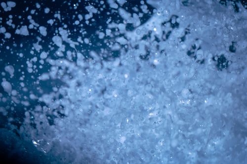 Free Close up of glowing drops of water splashing against dark background in darkness in nature outside during evening time in summer Stock Photo