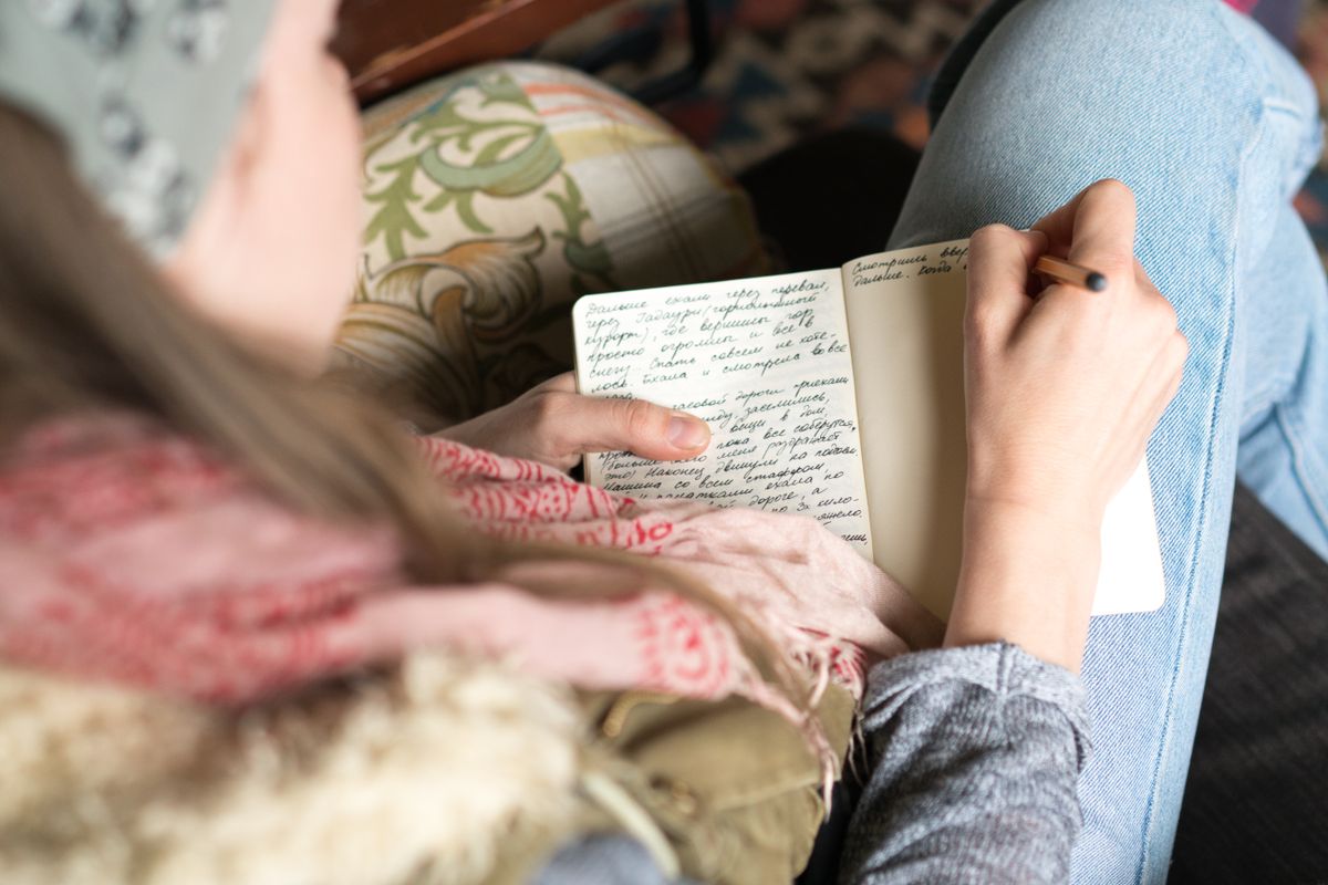 Woman journaling her perimenopause symptoms in a notebook