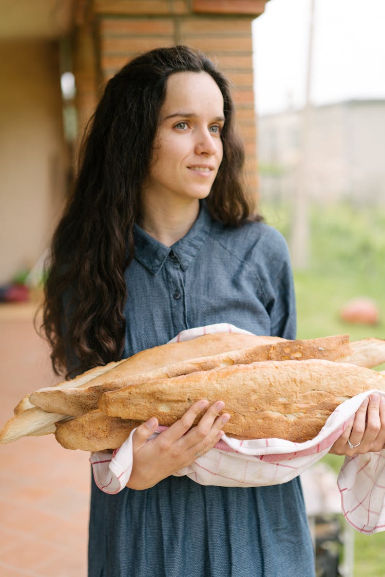 Woman In Blue Denim Button Up Shirt Holding Baguette