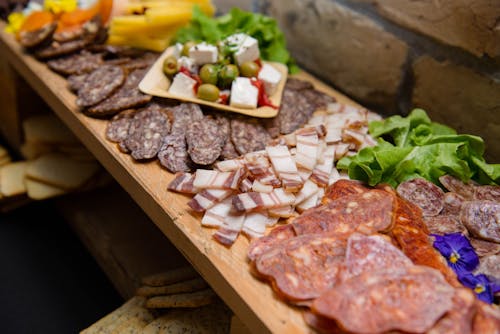 Free High angle appetizing sliced cured pork fat and smoked sausages served on sideboard with cheese and olives during buffet catering Stock Photo