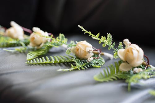 Collection of wedding flowers with long leaves placed on dark surface on blurred background