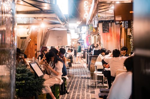 Free Experience the vibrant nightlife of Osaka's alleyway dining with people enjoying meals and socializing. Stock Photo