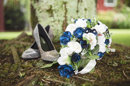 Colorful bridal bouquet near pair of shoes in summer