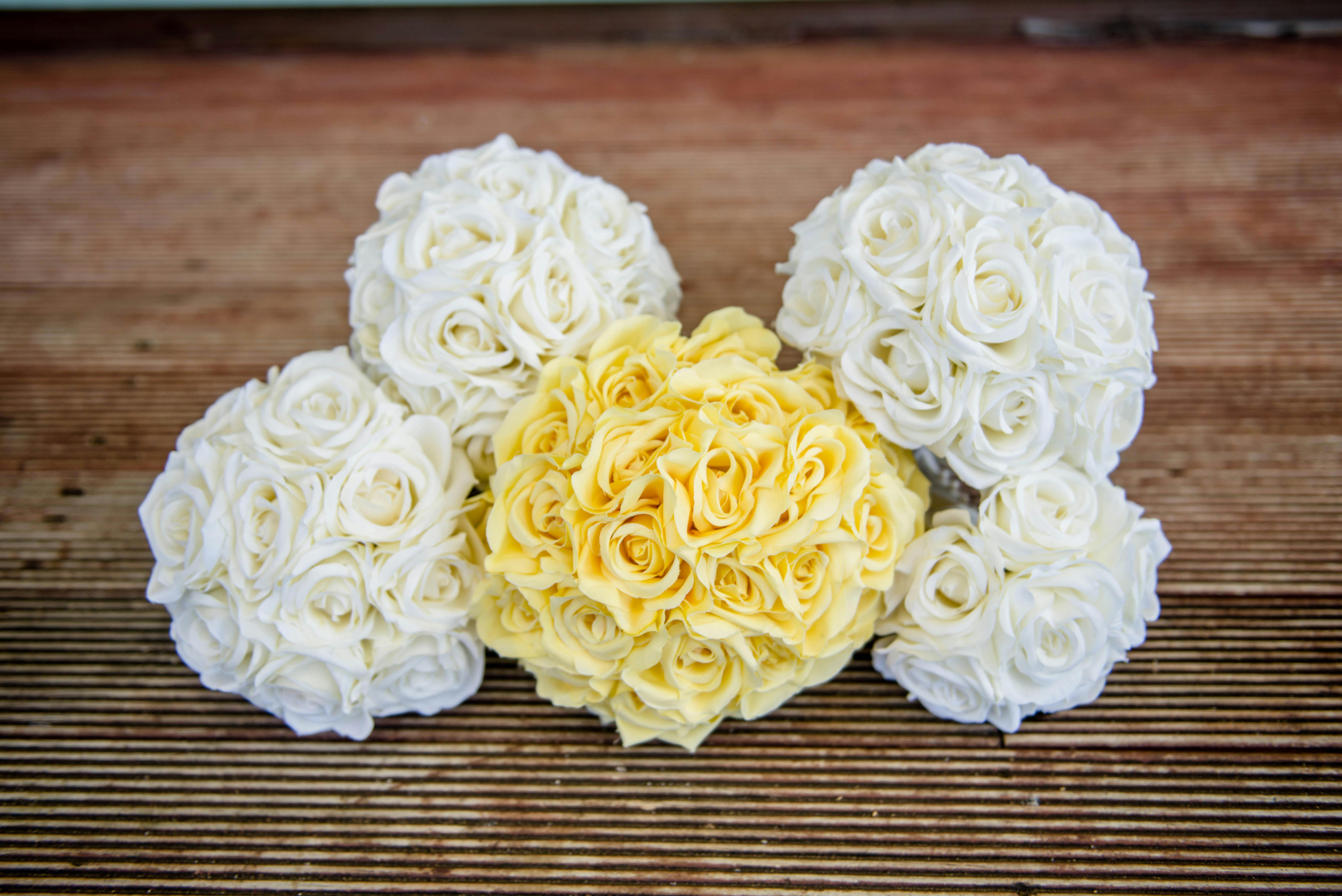 白色和黄色的新娘玫瑰在木制表面上排列得很漂亮