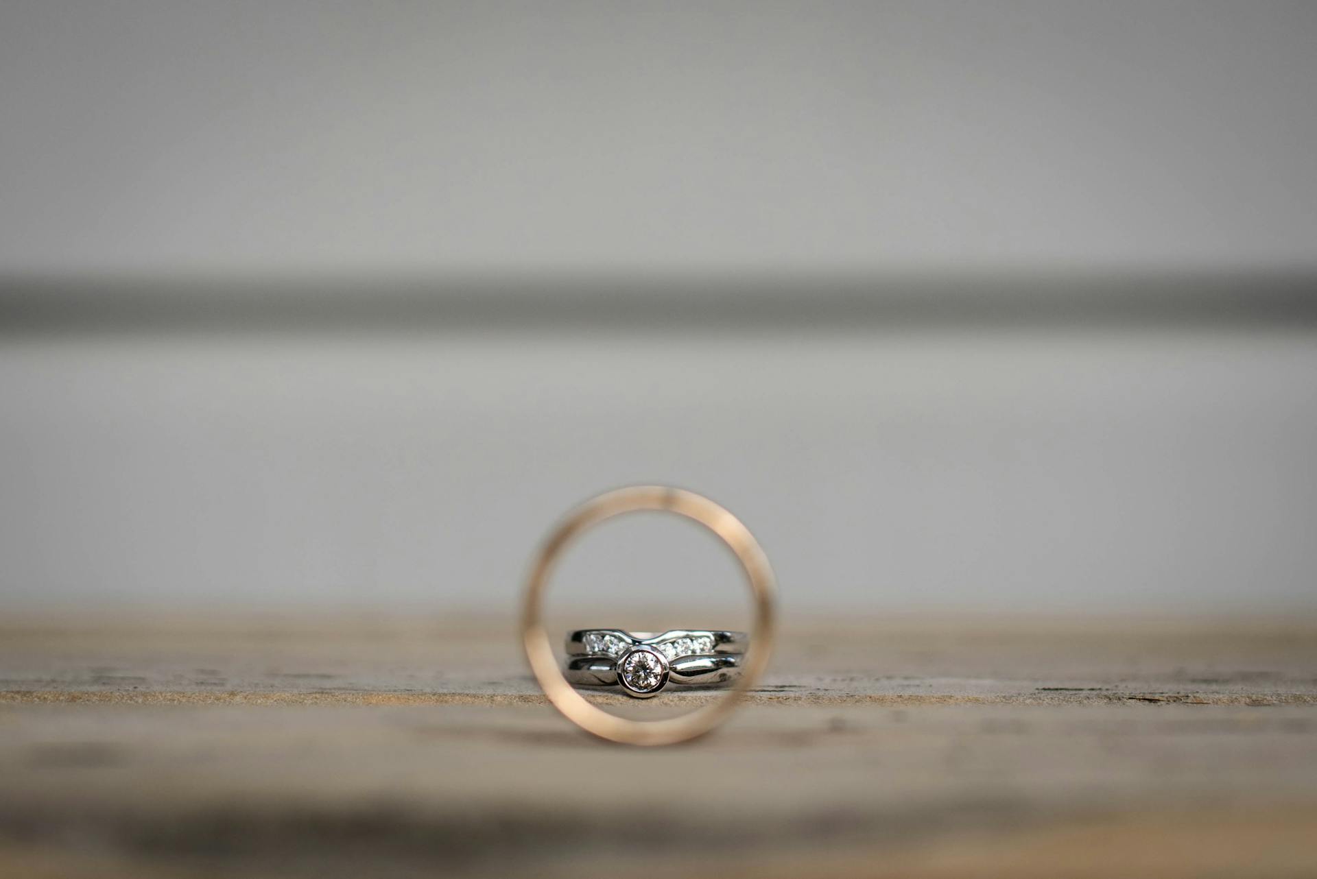 Closeup of golden and silver rings with precious stones on shabby surface on wedding day