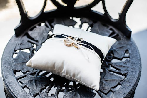 Decorative pillow with bridal rings on old chair