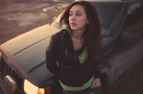 Woman in Black Leather Jacket Standing Beside Black Car