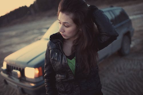 Free Woman in Black Leather Jacket Standing Near Car Stock Photo