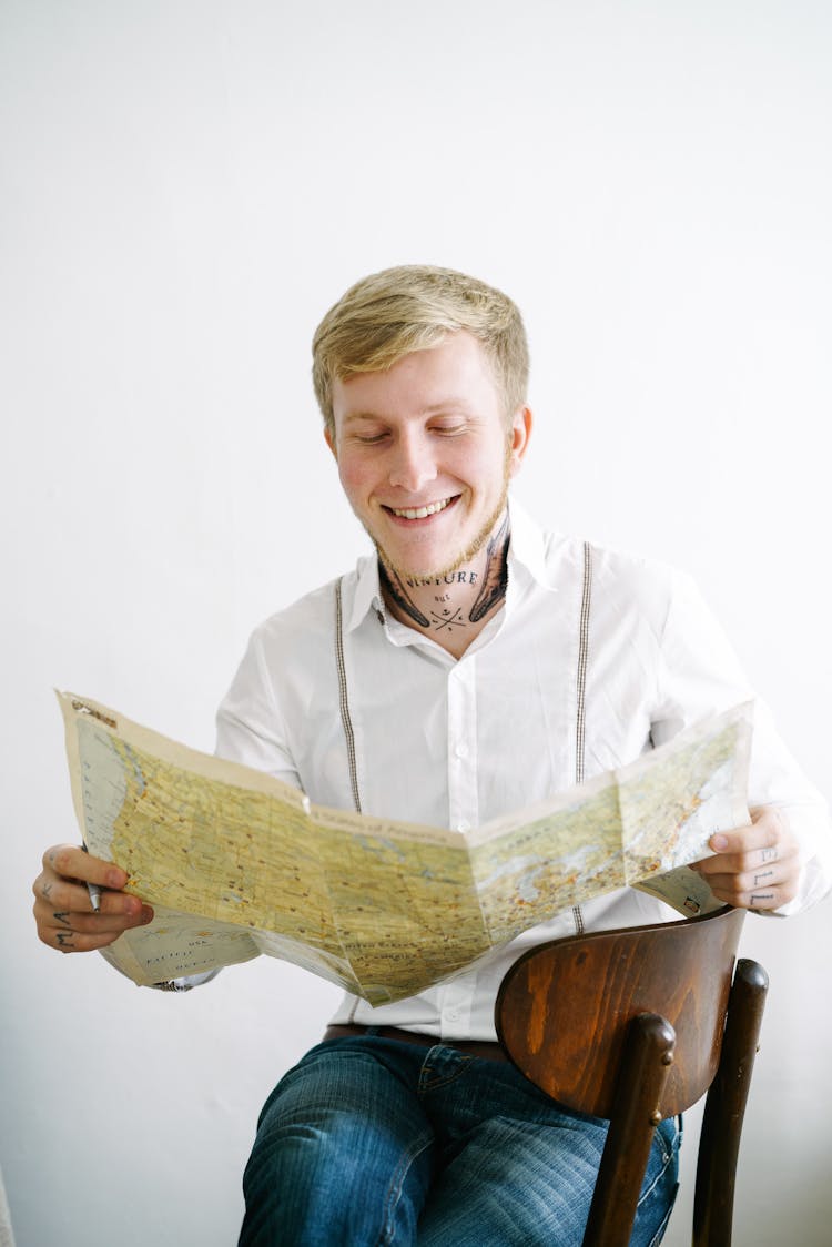 Man In White Dress Shirt Holding Map