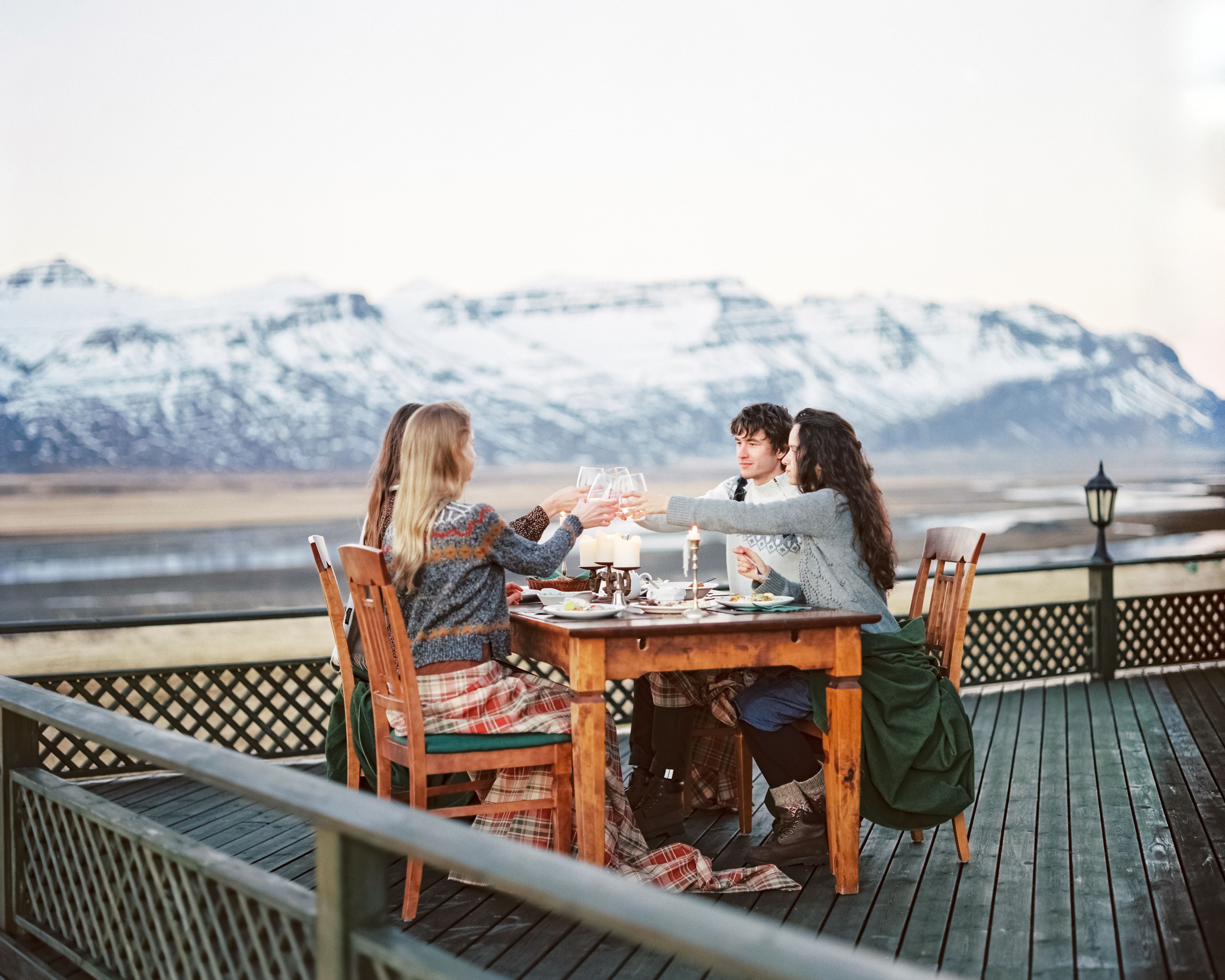 Friends enjoying a meal at an outdoor table with stunning mountain views.
