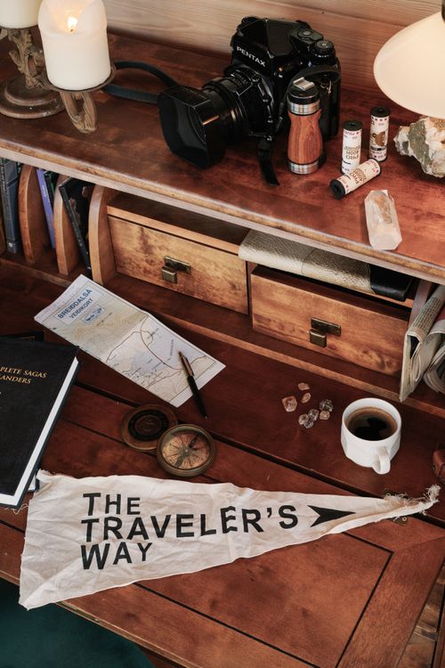 Free Explore adventure themes with this rustic desk setup featuring a camera, compass, and travel essentials. Stock Photo