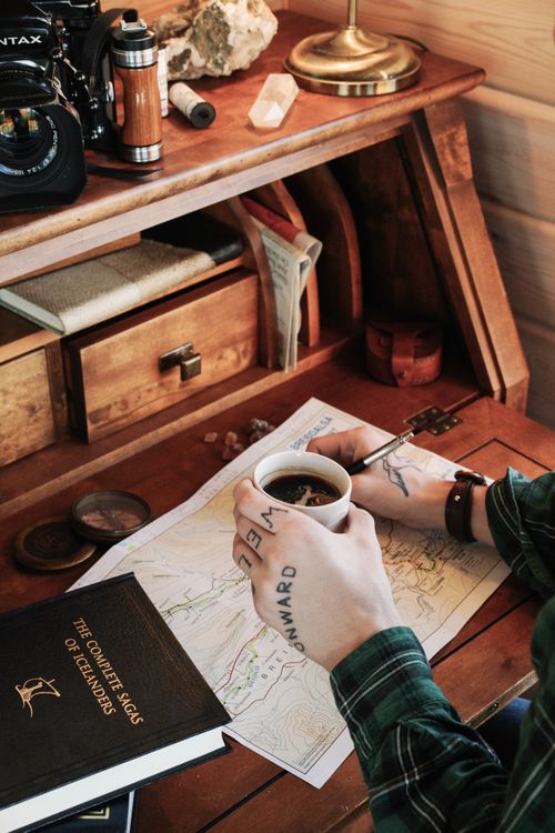 Free A vintage wooden desk setup with a map, coffee, and retro elements creating an old-fashioned ambiance. Stock Photo