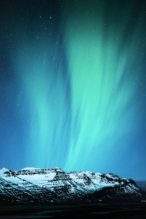 Snow Covered Mountain Under Beautiful Northern Lights in the Sky
