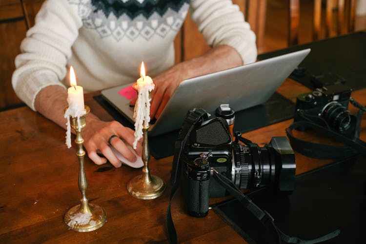 Photographer Working On Laptop In Candlelight