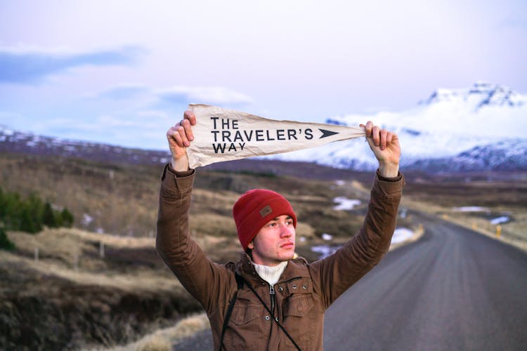 Man Showing The Travelers Way Text On Road