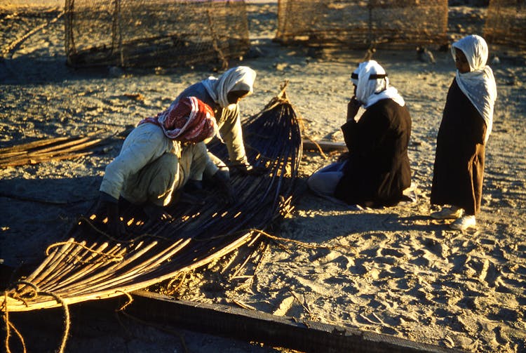 People Making Hammock On Sandy Ground