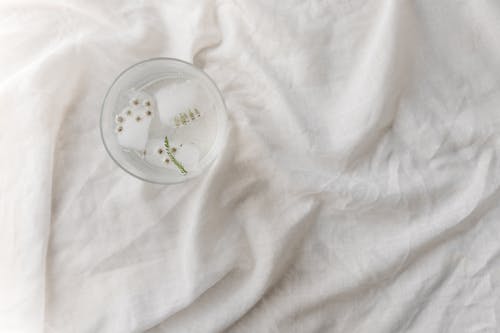 bardak, beyaz tekstil, bitki örtüsü içeren Ücretsiz stok fotoğraf