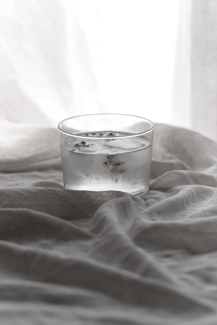 Close-Up Shot Of Water With Ice Cubes On White Textile