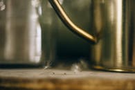 金色水壶旁漂浮的枸杞子艺术特写，捕捉了温暖的色调