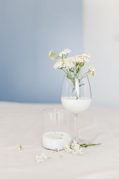 这幅极简主义静物画中，玻璃杯里盛着白花，配以牛奶，非常适合用作装饰主题