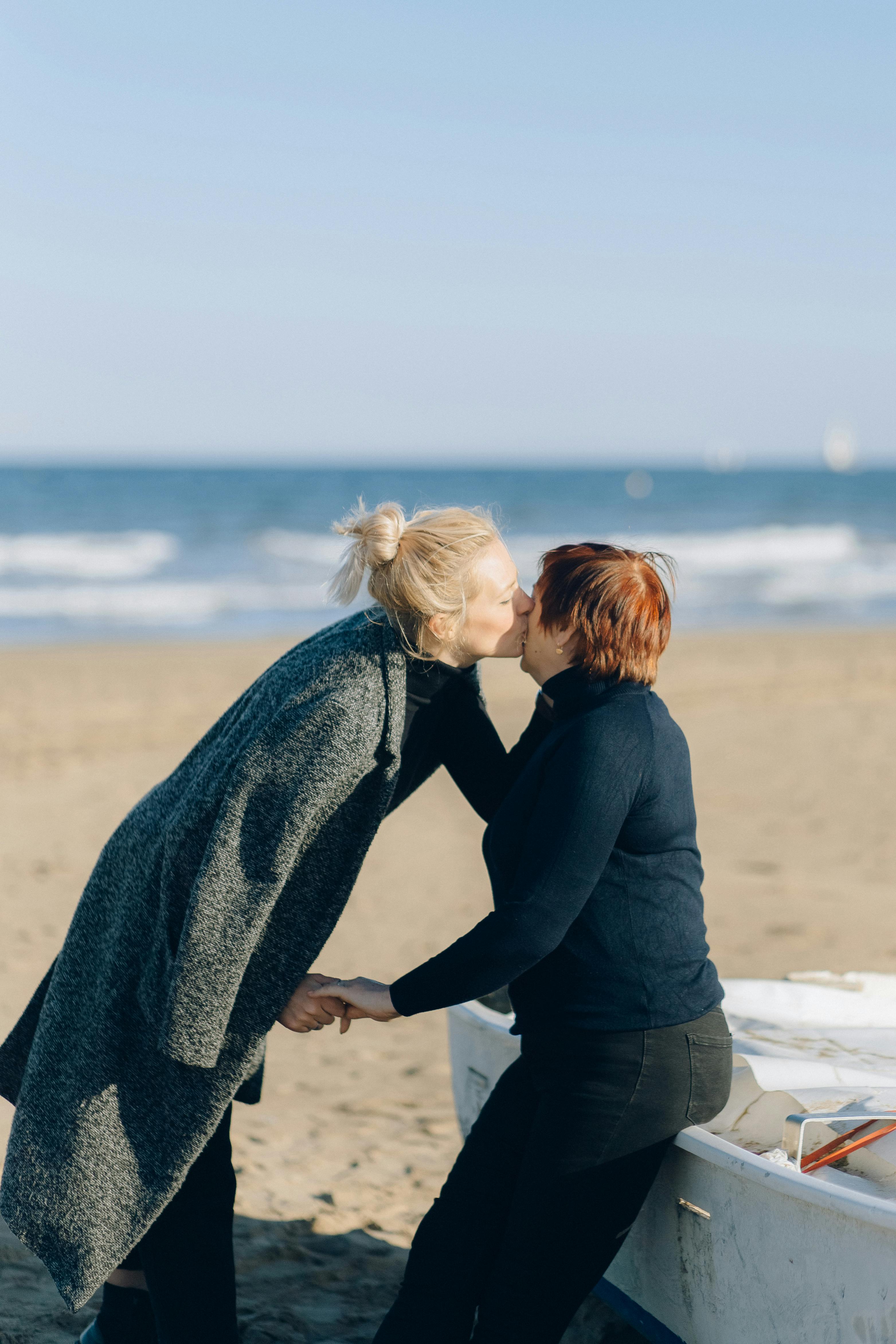 阳光明媚的海滩上，两个成年人分享着浪漫时刻，捕捉爱与团结