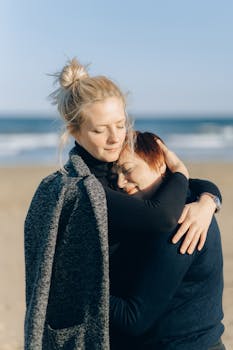 Heartwarming hug between mother and daughter on a sunny beach.