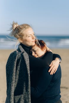 A mother and daughter embracing on a sunny beach, enjoying a moment of warmth and tenderness.