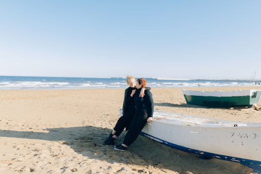Mother and daughter sit on a boat on a sunny beach, enjoying a moment of leisure and comfort.