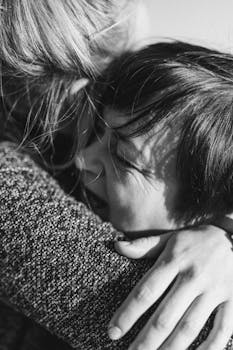 Heartfelt black and white portrait capturing a loving embrace between mother and child.