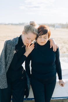 A warm, affectionate moment between a mother and daughter on a sunny beach day.