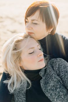 A warm moment of togetherness between a mother and daughter on a sunny beach.