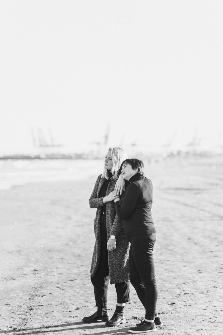 Grayscale Photo Of Lonely Mom And Daughter Standing At The Beach