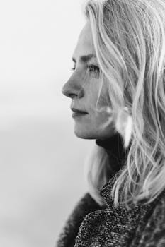 Side profile of a young woman in a contemplative black and white portrait.